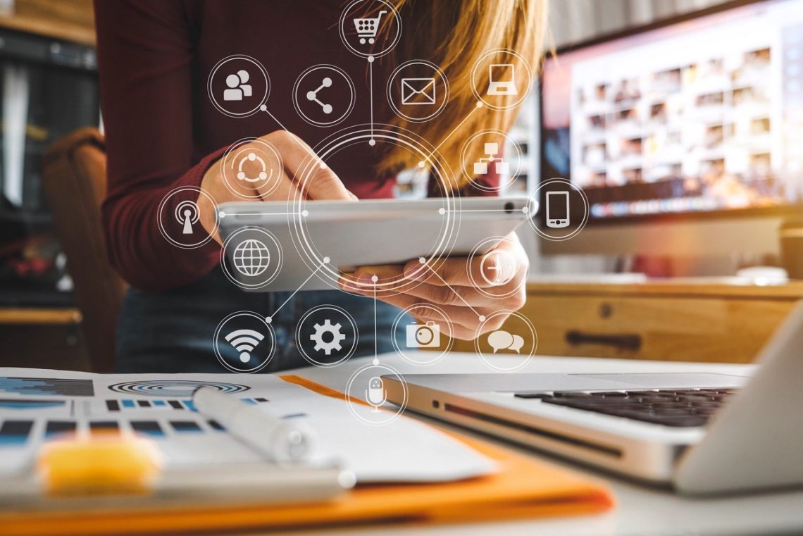 businesswoman hand working with laptop computer, tablet and smart phone in modern office with virtual icon diagram at modernoffice in morning light
