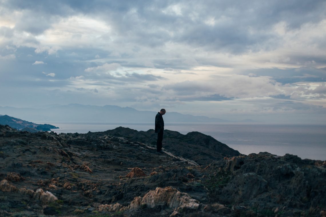 Silhouette of lonely and sad old man, stand in middle of rural and rocky landscape, watches sunset on horizon, deep lost in thoughts and dreams, Concept loneliness and dreams